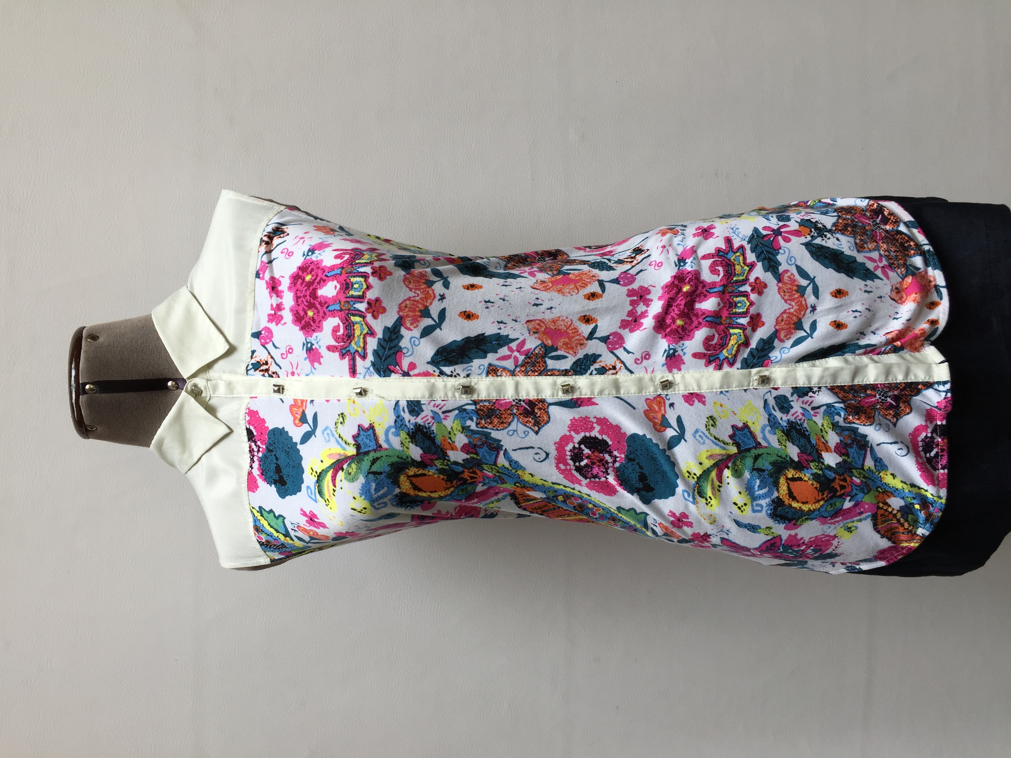 Blusa Basement de gasa crema superior y tela tipo algodón crema con estampado de flores inferior, manga cero y botones metálicos en el centro
Talla M